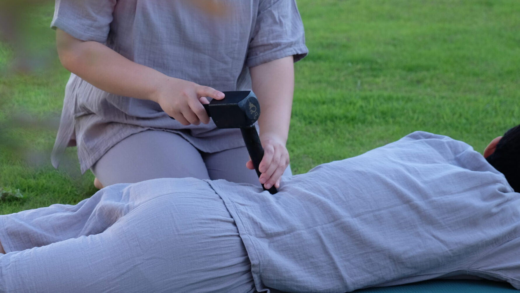 タイ伝統木槌療法のトークセンを屋外で施術している